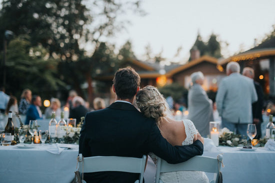 Bride and groom enjoying a scenic view of their romantic wedding, overlooking guests celebrating